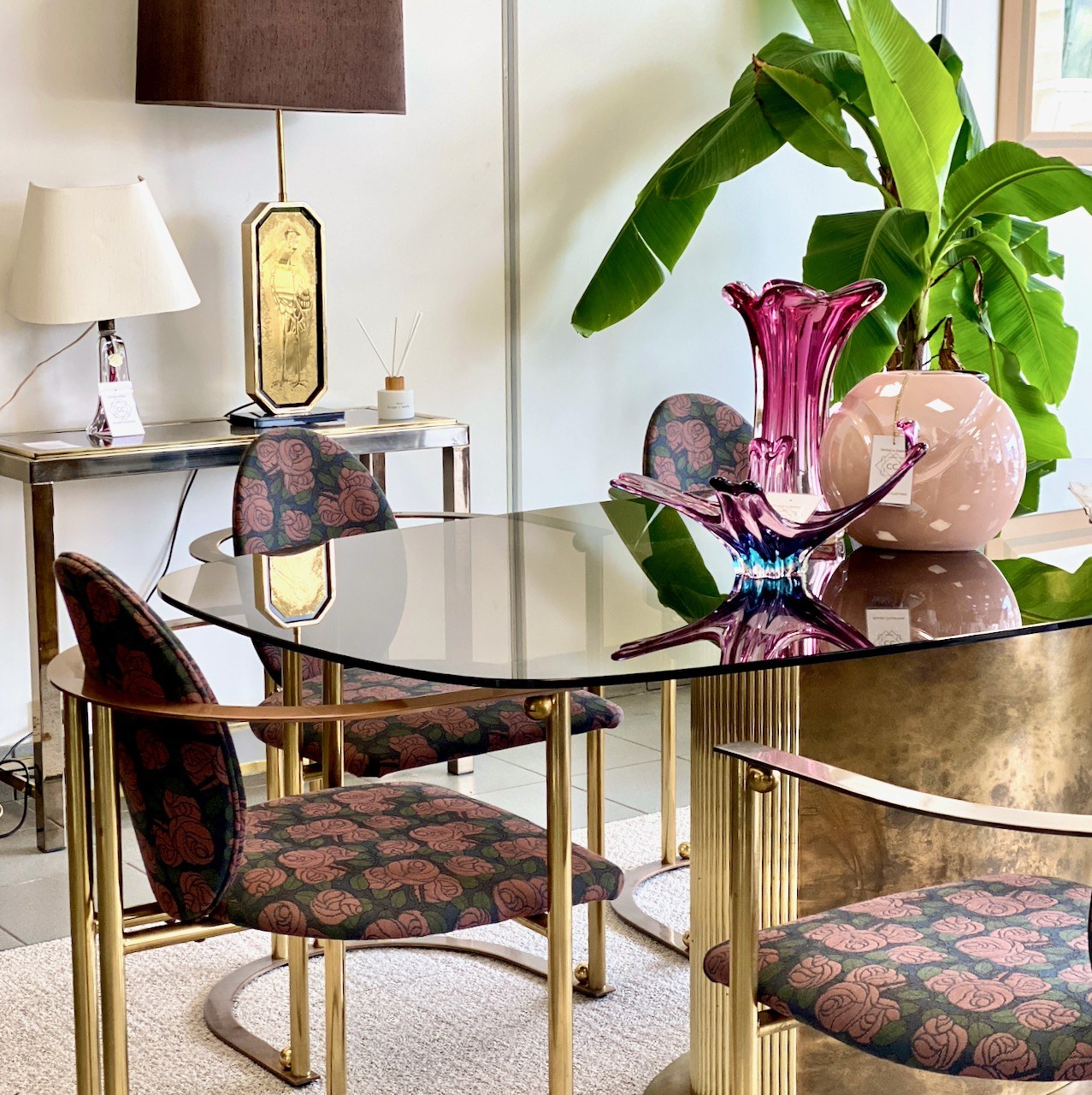 Ein gläserner Esstisch, geblümte Stühle, Leuchten und rosafarbenes Glas aus dem Showroom-Archiv von Claudia Collections