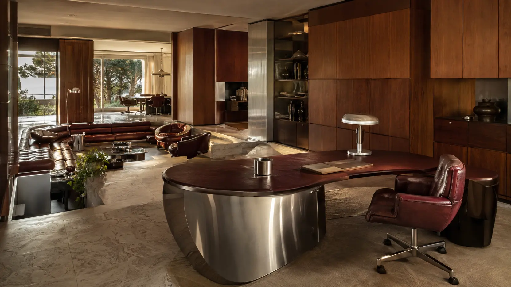 Een warm interieur met houten wandbekleding, een verchroomd bureau en leren zitmeubels